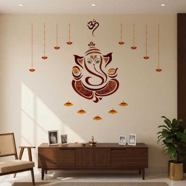 Decorative Lord Ganesha wall sticker featuring an Om symbol, hanging diyas, and floral lamp accents displayed above a wooden pooja altar with brass idols, flowers, and incense in a traditional home temple setting.