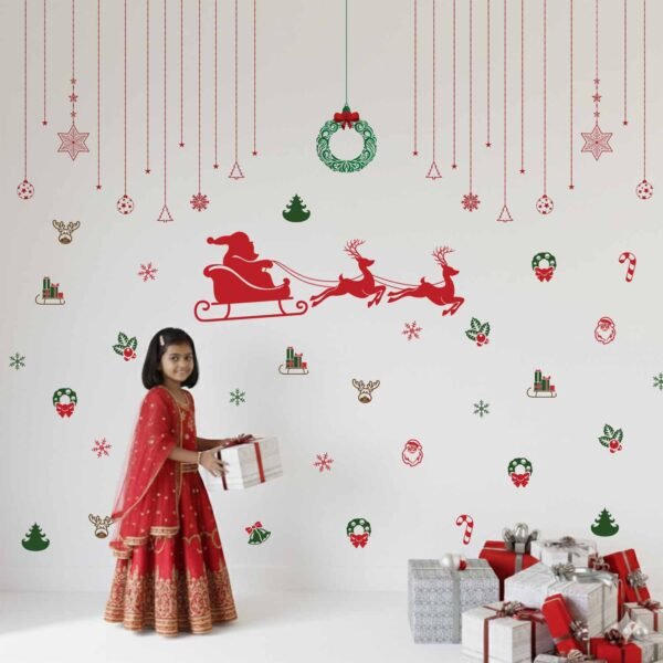 Christmas wall stickers featuring Santa sleigh, reindeer, wreaths, snowflakes, and festive hanging ornaments on a kids room wall