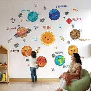 Kids room wall with colorful smiley solar system wall stickers including planets, sun, moon and space elements with child interacting